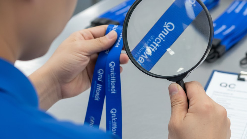 Factory staff performing quality control inspection on custom lanyards