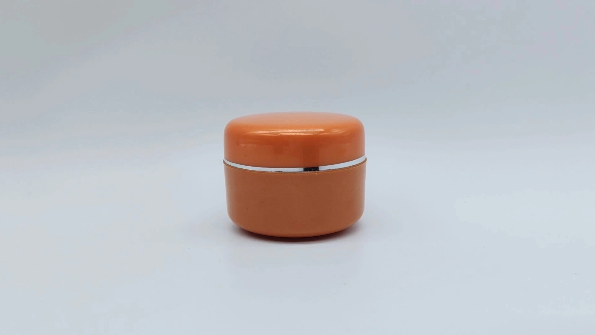Envase de crema para el cuidado de la piel facial y de las manos de plástico PE de 25 ml, con diseño de anillo naranja y plateado, venta al por mayor. 1