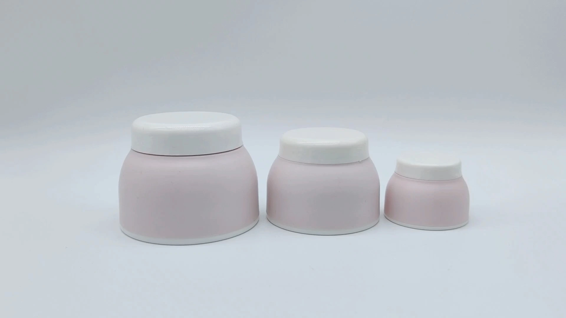 Envases de plástico PE para cremas faciales y de manos, ideales para el cuidado de la piel, en frascos de 50 ml, 25 ml y 10 ml, con diseños en rosa y blanco. 1