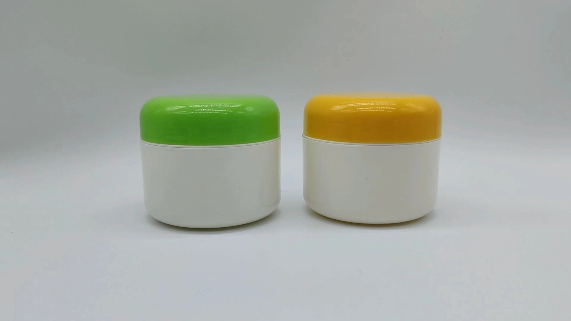 Kundenspezifische klassische zylinderförmige weiße Flasche mit verschiedenfarbigem Verschluss, 70 ml, Kunststoff-PE, Behälter für Gesichts- und Handpflegecreme, Kosmetikverpackungsgläser 1