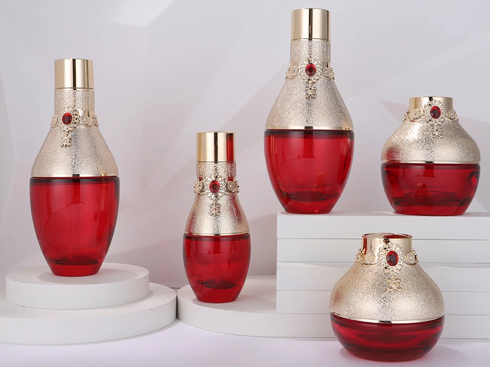 Pflegeverpackungsset aus leuchtend rotem Glas mit kunstvollen Gold- und Rubin-Akzenten | 120/100/40-ml-Flaschen und 50/30-g-Tiegel für luxuriöse Anti-Aging-Linien 1