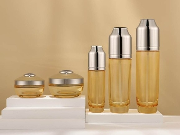 Set de envases transparentes color ámbar para el cuidado de la piel con tapas plateadas con efecto espejo | Frascos de 120/100/40 ml y tarros de 50/30 g para líneas antiedad de alta gama 1