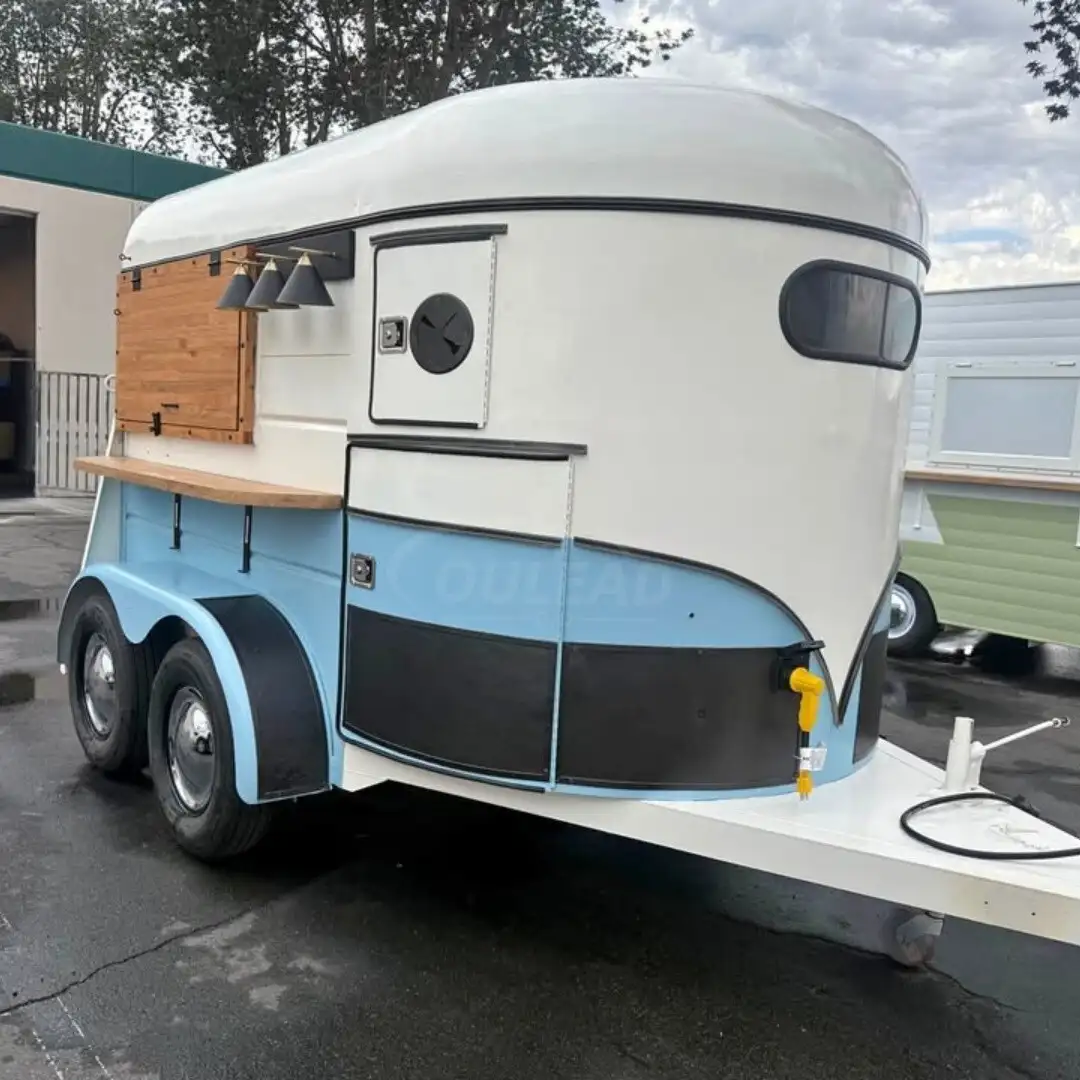 Remolque de comida retro de dos tonos, azul y blanco, con detalles de madera y luces colgantes. 1